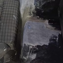 takieczyste.pl Rafał Sujecki - Wnętrze samochodu po praniu tapicerki: mokra podłoga i fotele z widocznymi śladami czyszczenia, plamy usunięte, widoczne detale tapicerki.