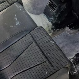 takieczyste.pl Rafał Sujecki - Wnętrze samochodu po czyszczeniu: widoczne mokre fotele z tkaniny w prążki i wilgotna podłoga, pozostałości po praniu. Detal na kratce wentylacyjnej.