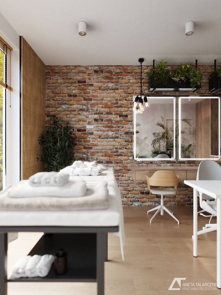 Jasne wnętrze gabinetu w Warszawie z ceglaną ścianą, stołem do zabiegów przykrytym białymi ręcznikami, drewnianą podłogą i nowoczesnym oświetleniem.