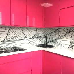 Zakład Szklarski Roman Lizoń - Różowa kuchnia z ozdobnym panelem szklanym nad blatem. Czarna armatura i płyta grzewcza. Minimalistyczny design z abstrakcyjnym wzorem fal.