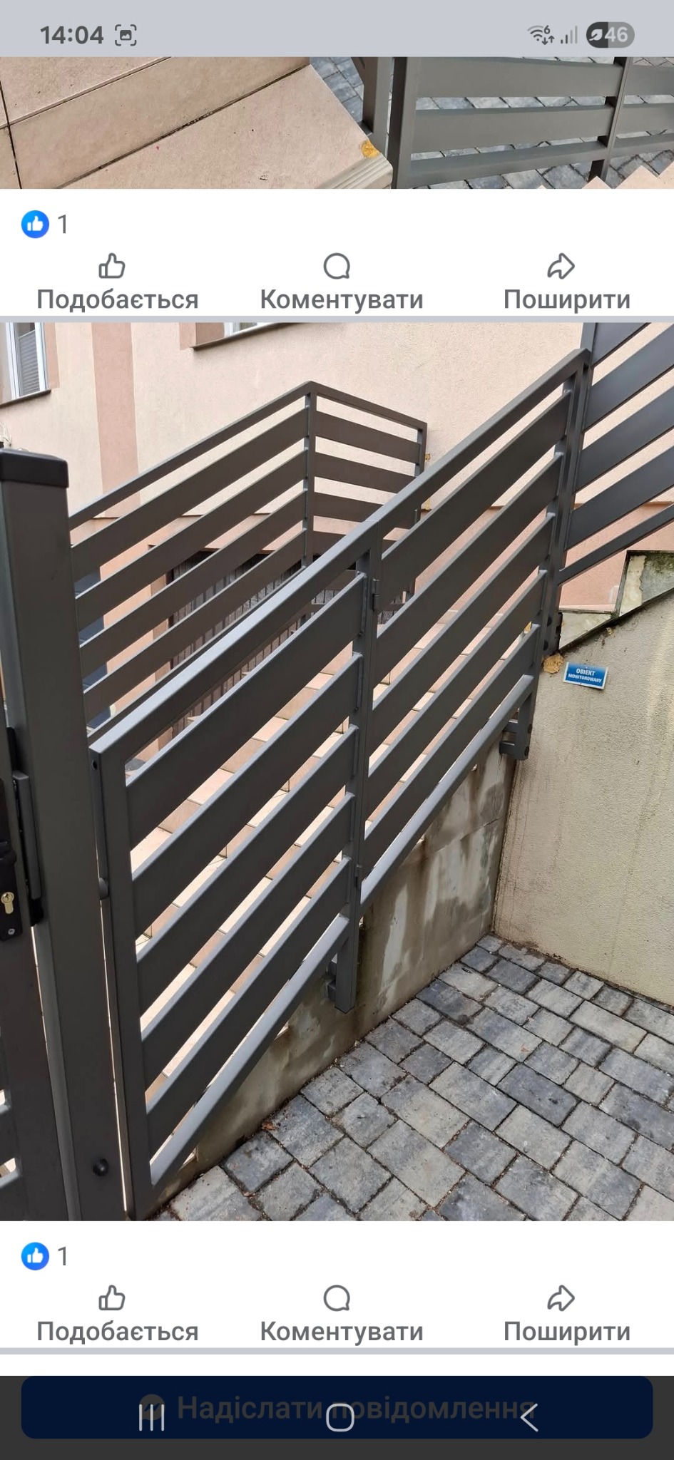 Nowoczesna, szara brama metalowa z poziomymi szczeblami, prowadząca do schodów. Widoczny fragment budynku w tle i kostka brukowa na podłożu.