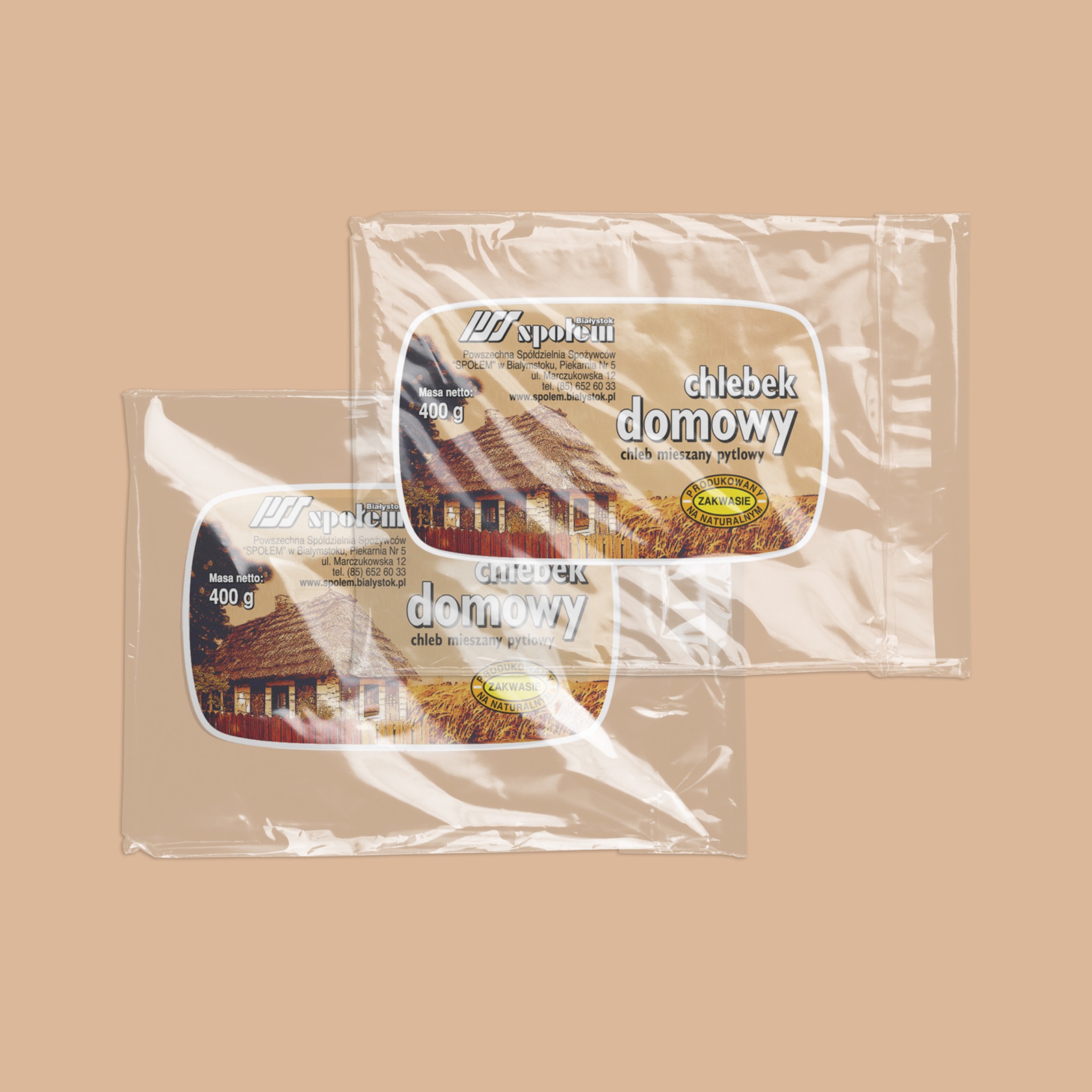 Dwa opakowania chleba 'Chlebek Domowy' firmy Społem Białystok, z grafiką wiejskiej chaty i napisem 'Produkowany na zakwasie naturalnym', na beżowym tle.