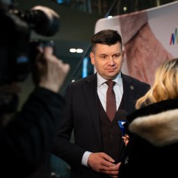 Władysław Turański - Mężczyzna w garniturze udziela wywiadu, otoczony przez dziennikarzy i kamery, na tle logo Małopolska.