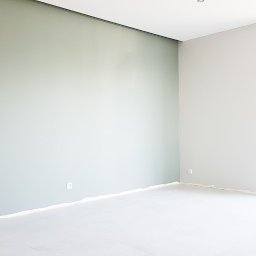 WALLCRAFT SPÓŁKA Z OGRANICZONĄ ODPOWIEDZIALNOŚCIĄ - Jasne, świeżo pomalowane wnętrze pokoju z dwoma odcieniami szarości na ścianach. Widoczne gniazdka elektryczne i duże okno z widokiem na zieleń.