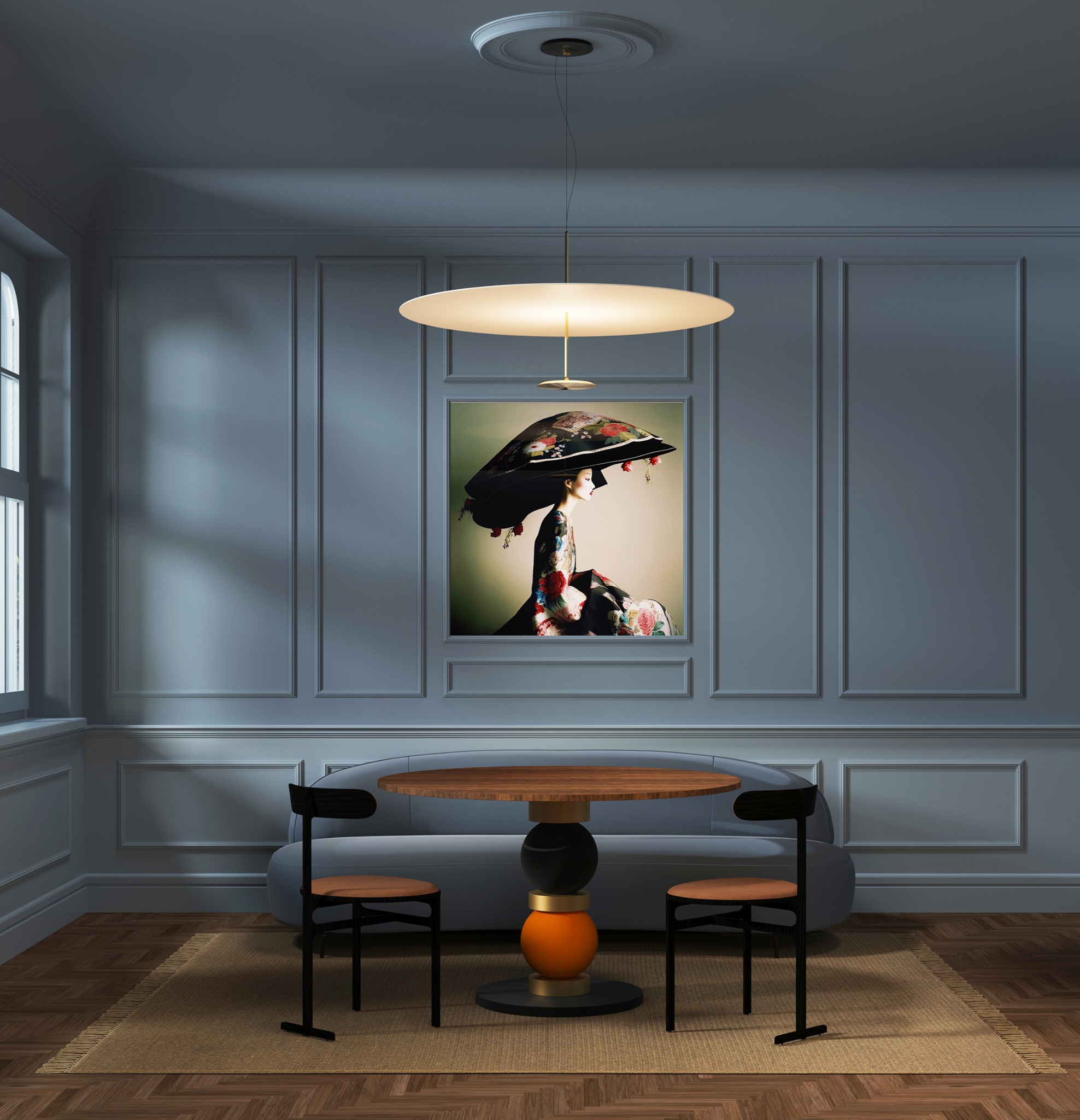 Stylowe wnętrze: okrągły stół z krzesłami na tle szarej sofy i ściany w panelach. Nad stołem nowoczesna lampa, a na ścianie obraz w ramie.