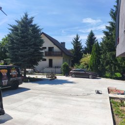 Betonoza - Duży, równy podjazd z jasnego betonu przed domem w Krakowie, z widoczną firmową furgonetką i narzędziami, sugerujący świeżo wykonane prace nawierzchniowe.