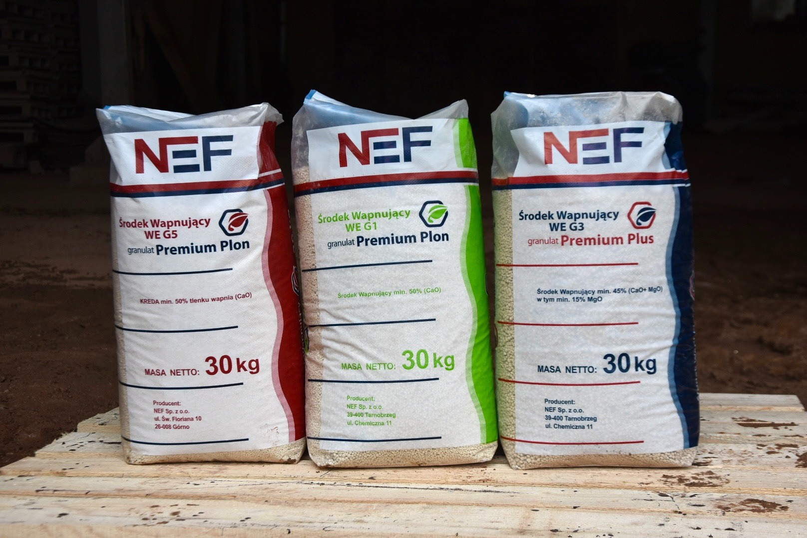 Trzy worki nawozu wapniowego NEF (WE G5, WE G1, WE G3) o wadze 30 kg każdy, stojące obok siebie, z widocznymi danymi producenta i składem.
