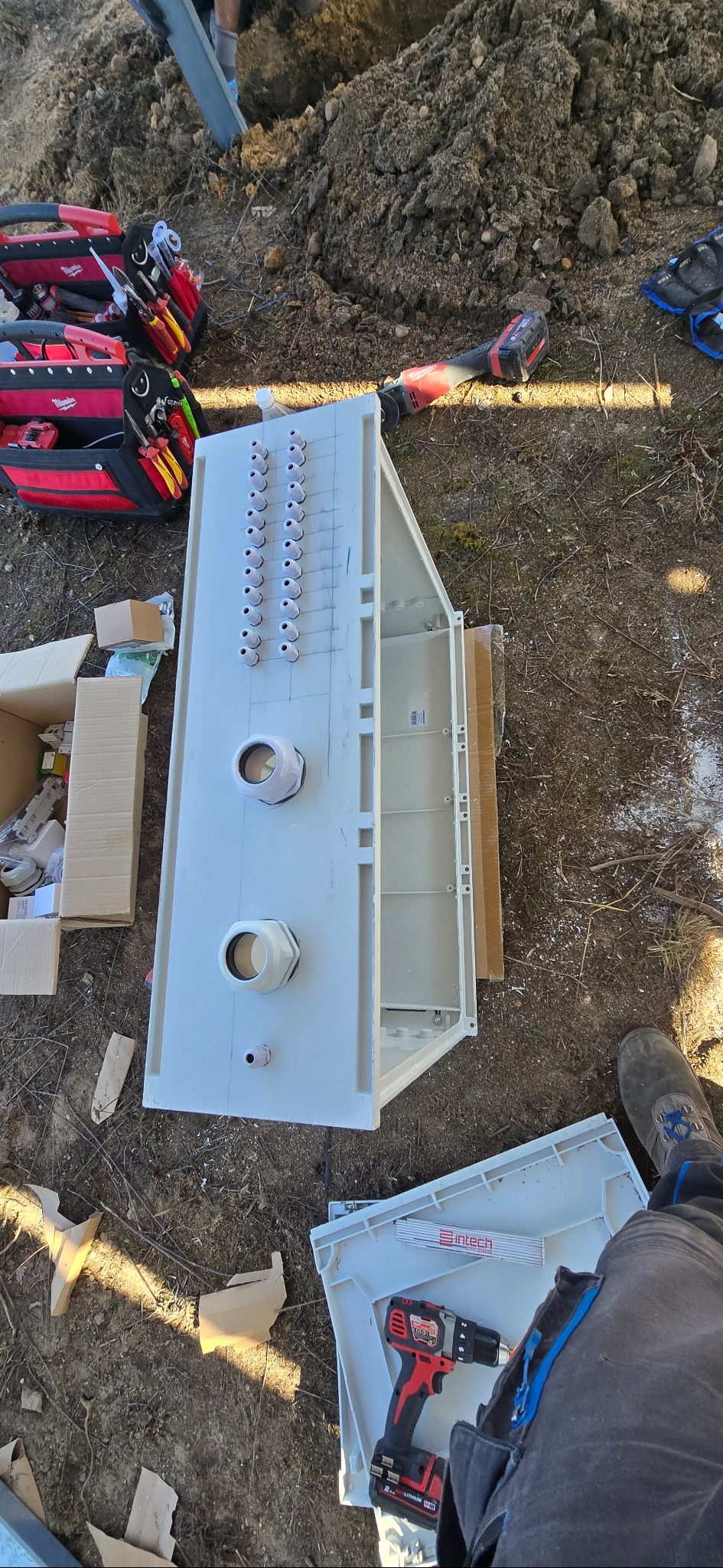 Rozdzielnica elektryczna w trakcie montażu instalacji fotowoltaicznej w Kiczycach, widoczne narzędzia i skrzynka z elementami. Praca w toku, przygotowanie do instalacji.