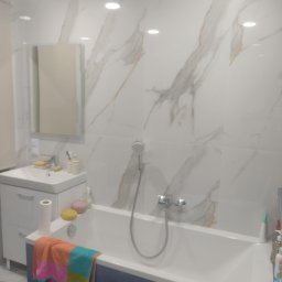 Tomasz Dąbrowski Arsen Usługi Glazurnicze - Biała łazienka z wanną, umywalką i lustrem. Ściany wyłożone płytkami imitującymi marmur z delikatnymi złotymi żyłkami. Na wannie leżą kolorowe ręczniki i akcesoria.