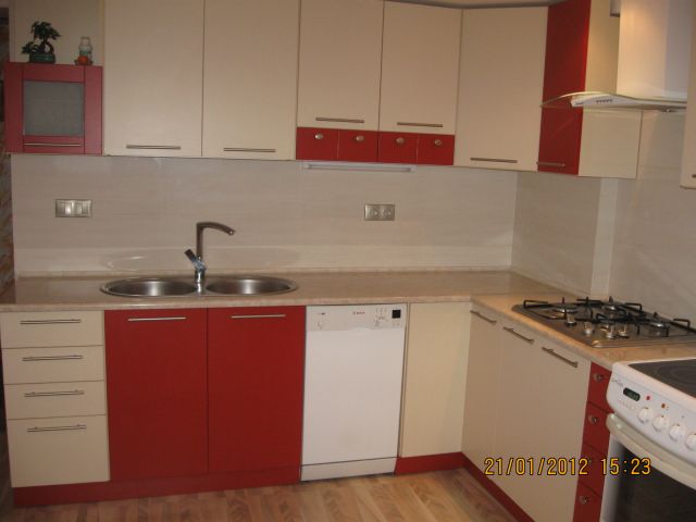 Kremowo-czerwone meble kuchenne na wymiar z podwójnym zlewem i płytą gazową, zrealizowane w Poznaniu.