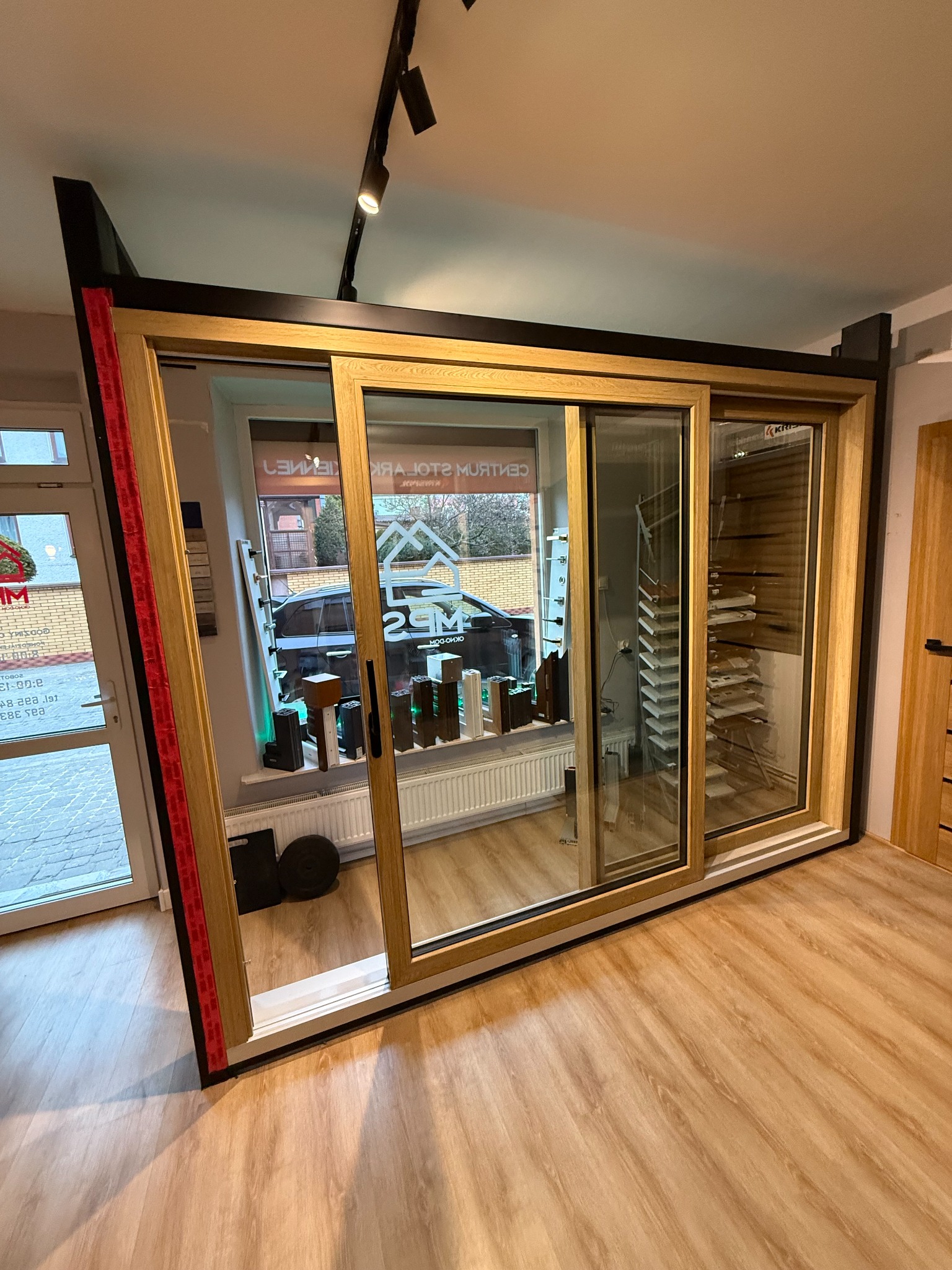 Prezentacja dużych, przesuwnych drzwi balkonowych z drewnianą ramą, eksponowanych w salonie. Widoczne detale konstrukcyjne i przeszklenia.