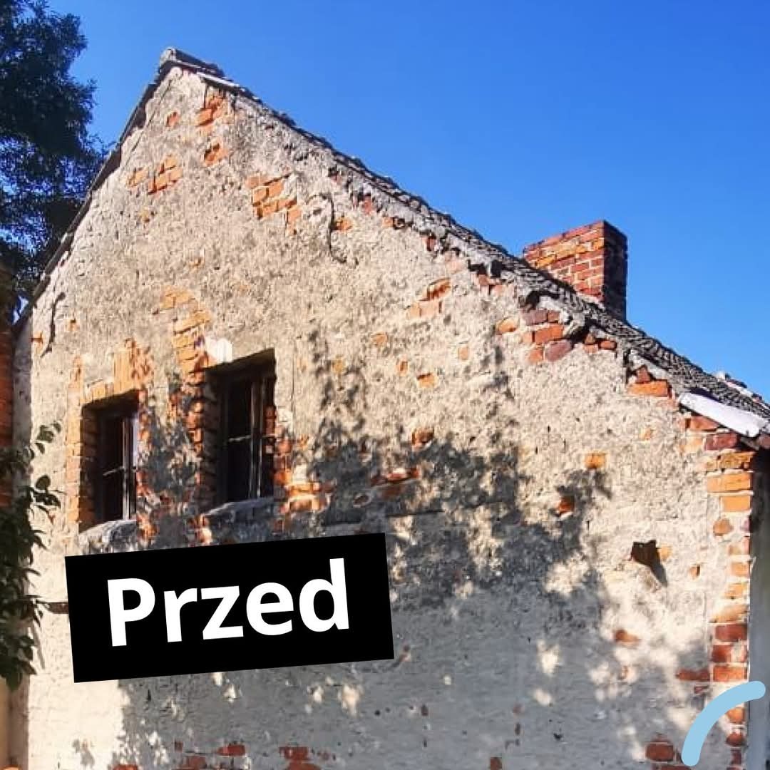 Dom z wyraźnymi śladami zniszczeń na elewacji, z napisem 'Przed' w rogu, sugerujący stan przed renowacją. Widoczne cegły i ubytki w tynku.