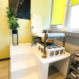 Gabinet Kosmetyki Laserowej i Stylizacji Paznokci Dorota Musidlak - Wnętrze gabinetu kosmetycznego z fotelem, urządzeniem do zabiegów i dekoracjami. Widoczny napis 'GABINET KOSMETYKI LASEROWEJ'.