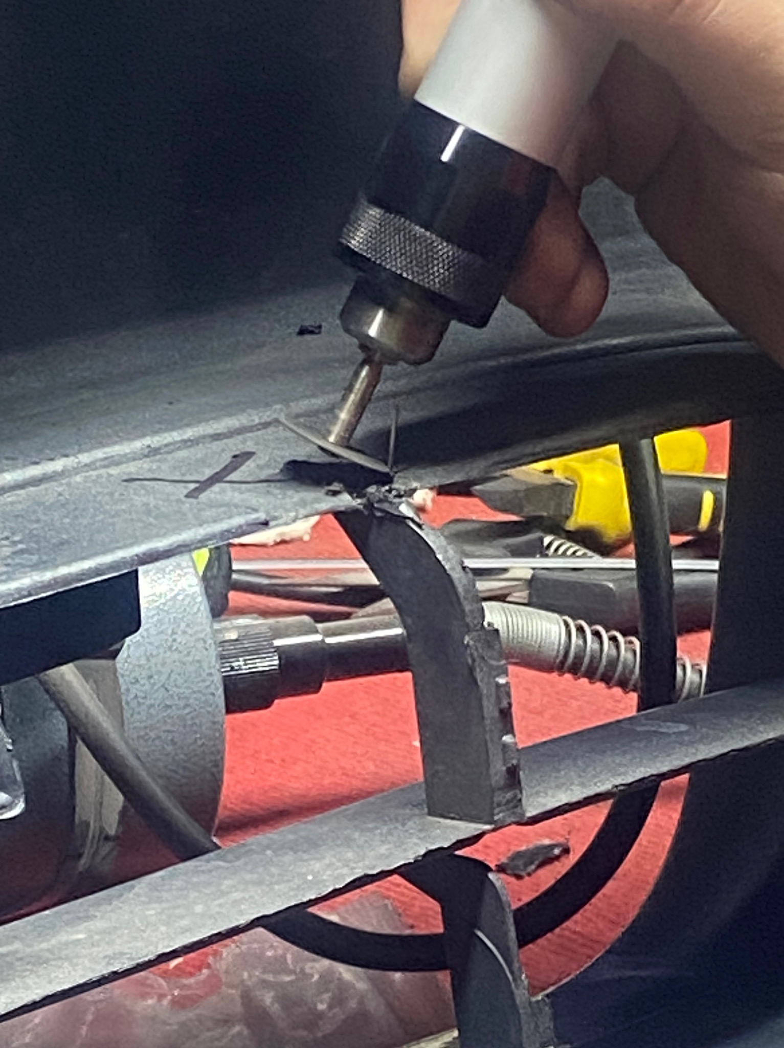 Precyzyjne spawanie uszkodzonego metalowego elementu konstrukcyjnego, widoczne narzędzie i drobne iskry. Ujęcie z bliska, skupione na detalu naprawy.