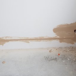 Fresh Art - Przygotowanie do prac wykończeniowych: widoczne kable elektryczne w ścianie, otwory po gniazdkach i fragment płyty karton-gips, szpachlowanie.