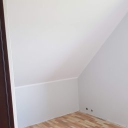 Fresh Art - Poddasze po malowaniu na biało, widoczne narzędzia malarskie i wiadro z farbą Atlas GTA. Podłoga wyłożona panelami imitującymi drewno. Świeżo pomalowane ściany.