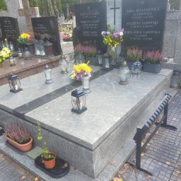 Kamil Jaszczyński - Podwójny nagrobek z jasnego i ciemnego granitu (Viscount White i Premium Black) z kwiatami i lampionami na cmentarzu, jesienne liście na ziemi.