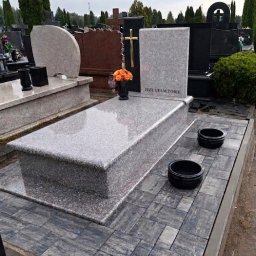 Kamil Jaszczyński - Jasnoszary, podwójny pomnik z napisem 'Jezu ufam Tobie', złotym krzyżem i kwiatami, otoczony szarą kostką brukową na cmentarzu.