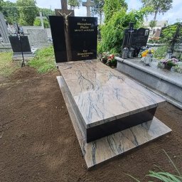 Kamil Jaszczyński - Nowoczesny pomnik cmentarny z polerowanego czarnego granitu i jasnego marmuru o unikalnym wzorze, z metalowym krucyfiksem, świeżo osadzony na ziemi.