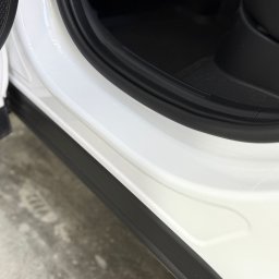 RENT-IPSUM TOMASZ ZIENTARA - Wnętrze białego samochodu z widocznym progiem i uszczelką drzwi. Detal czystego, zadbanego wnętrza pojazdu z bliska.