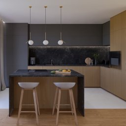 KAWI Studio Projektowania Wnętrz - Nowoczesna kuchnia z wyspą, drewnianymi szafkami i blatem z ciemnego kamienia. Nad wyspą wiszą trzy lampy z okrągłymi kloszami. Minimalistyczny design, naturalne światło.