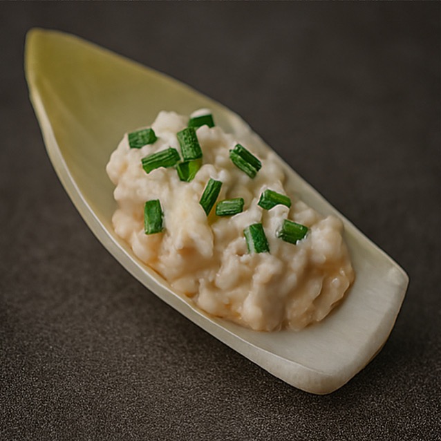 Kremowa pasta z zieleniną na łódeczce z cykorii, zbliżenie. Elegancka przekąska cateringowa, idealna na przyjęcia i eventy firmowe. Stonowana kolorystyka.