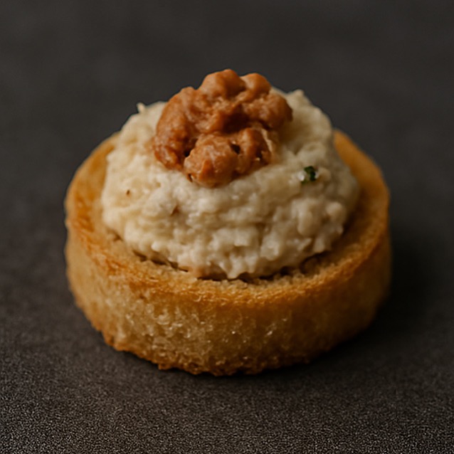 Apetyczna kanapka z pastą i orzechem włoskim na ciemnym tle. Elegancka przekąska cateringowa, idealna na przyjęcia i eventy firmowe. Makro, ostre detale.