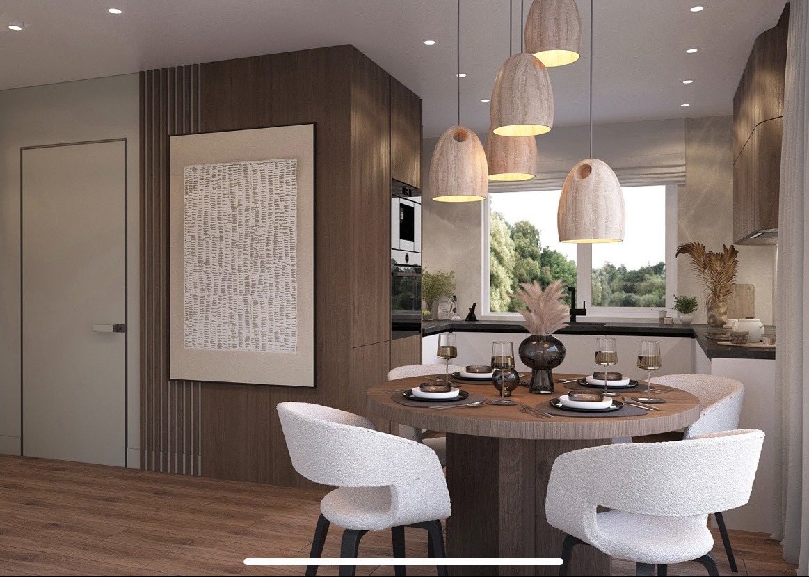 Nowoczesna jadalnia z okrągłym stołem, białymi krzesłami i wiszącymi lampami. Minimalistyczny design z drewnianymi akcentami i dekoracyjnym obrazem na ścianie.