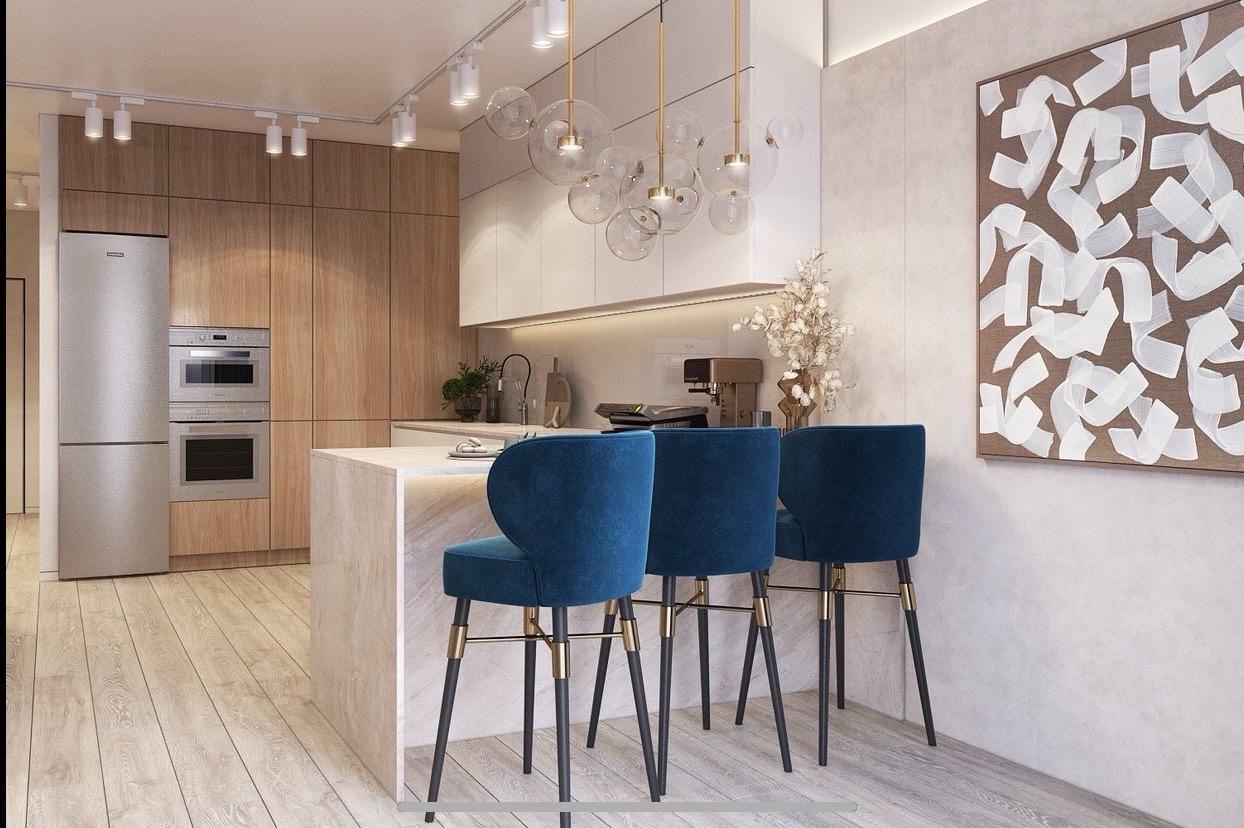 Nowoczesna kuchnia z drewnianymi szafkami, wyspą z marmurowym blatem i trzema granatowymi krzesłami barowymi. Nad wyspą designerska lampa.