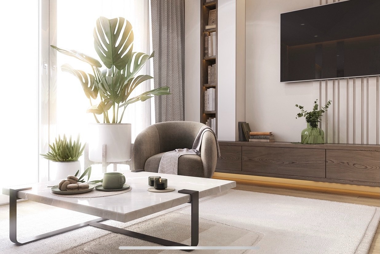 Jasne wnętrze salonu z marmurowym stolikiem, roślinami w doniczkach, szarym fotelem i zabudową meblową z telewizorem. Stonowana kolorystyka, naturalne światło.