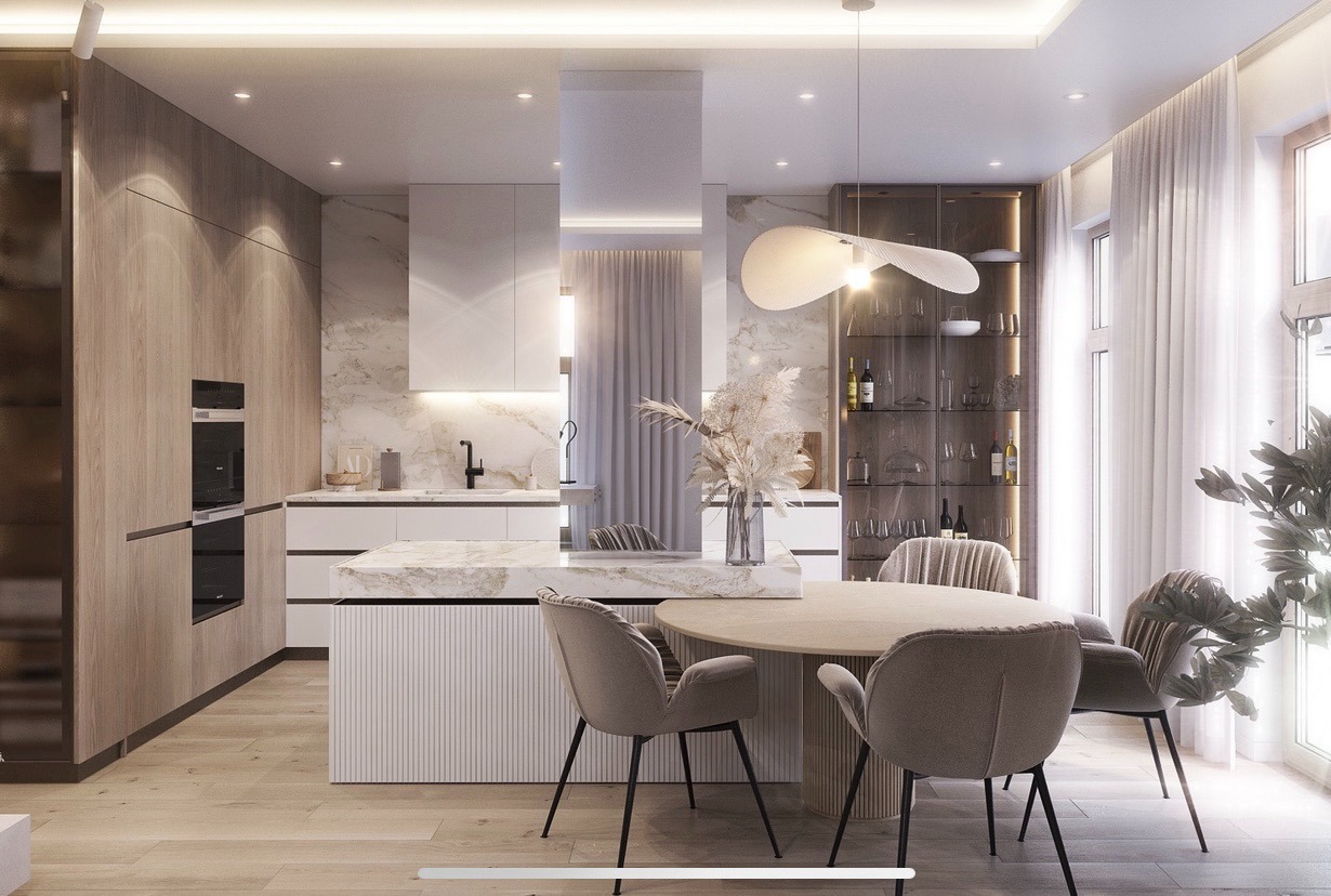 Elegancka kuchnia z wyspą i okrągłym stołem jadalnym, oświetlona wiszącą lampą. Marmur na ścianie, drewniane fronty i przeszklona witryna dodają luksusowego charakteru.