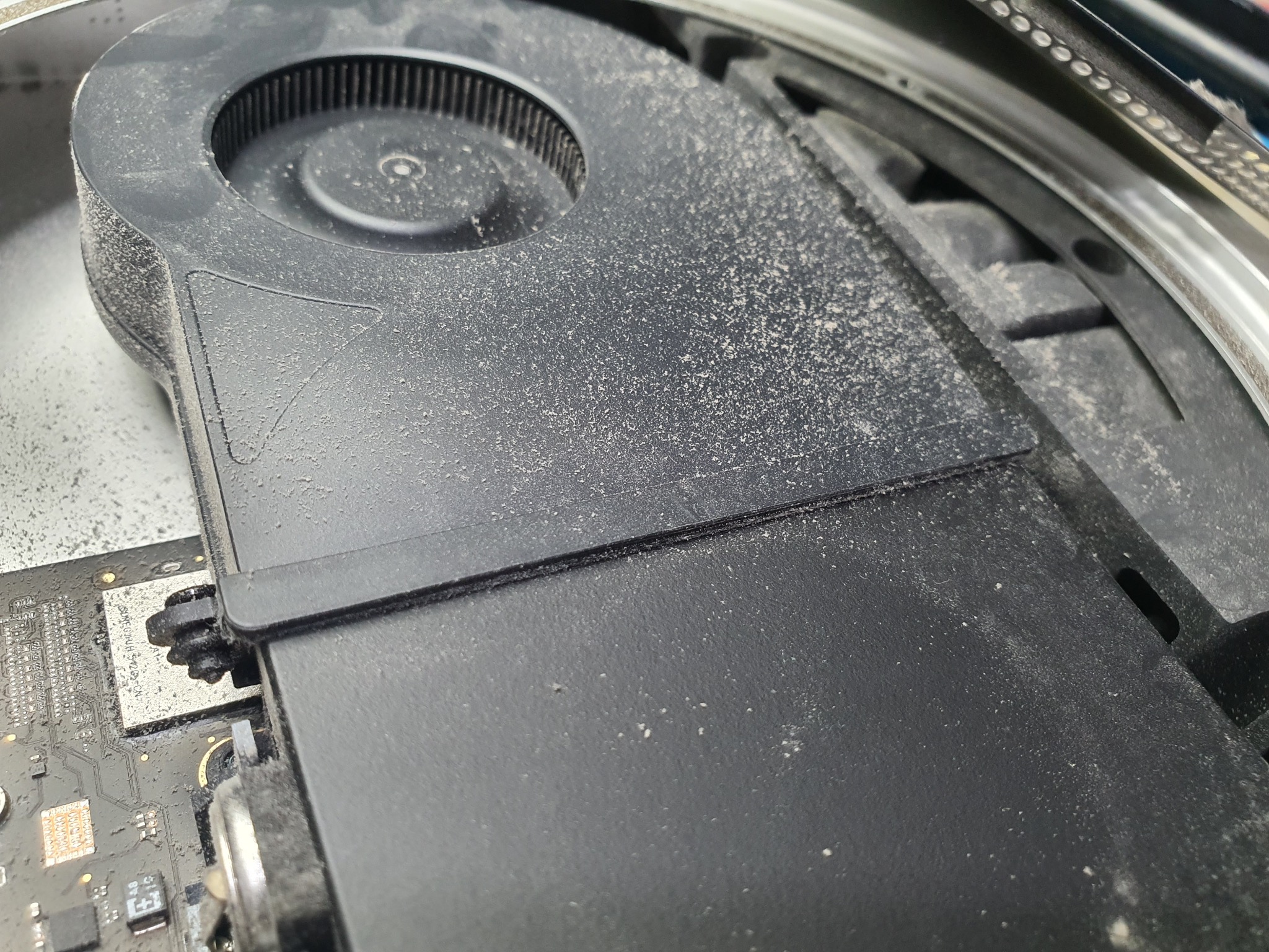 Zakurzony wentylator komputera stacjonarnego, widoczna płyta główna. Konieczność czyszczenia w celu uniknięcia przegrzewania i awarii.