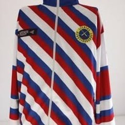 KL SPORT SPÓŁKA Z OGRANICZONĄ ODPOWIEDZIALNOŚCIĄ - Rozpięta bluza dresowa w biało-czerwono-niebieskie pasy, z logo na piersi i naszywką na ramieniu, na jasnym tle. Widok z przodu, lekko z góry.