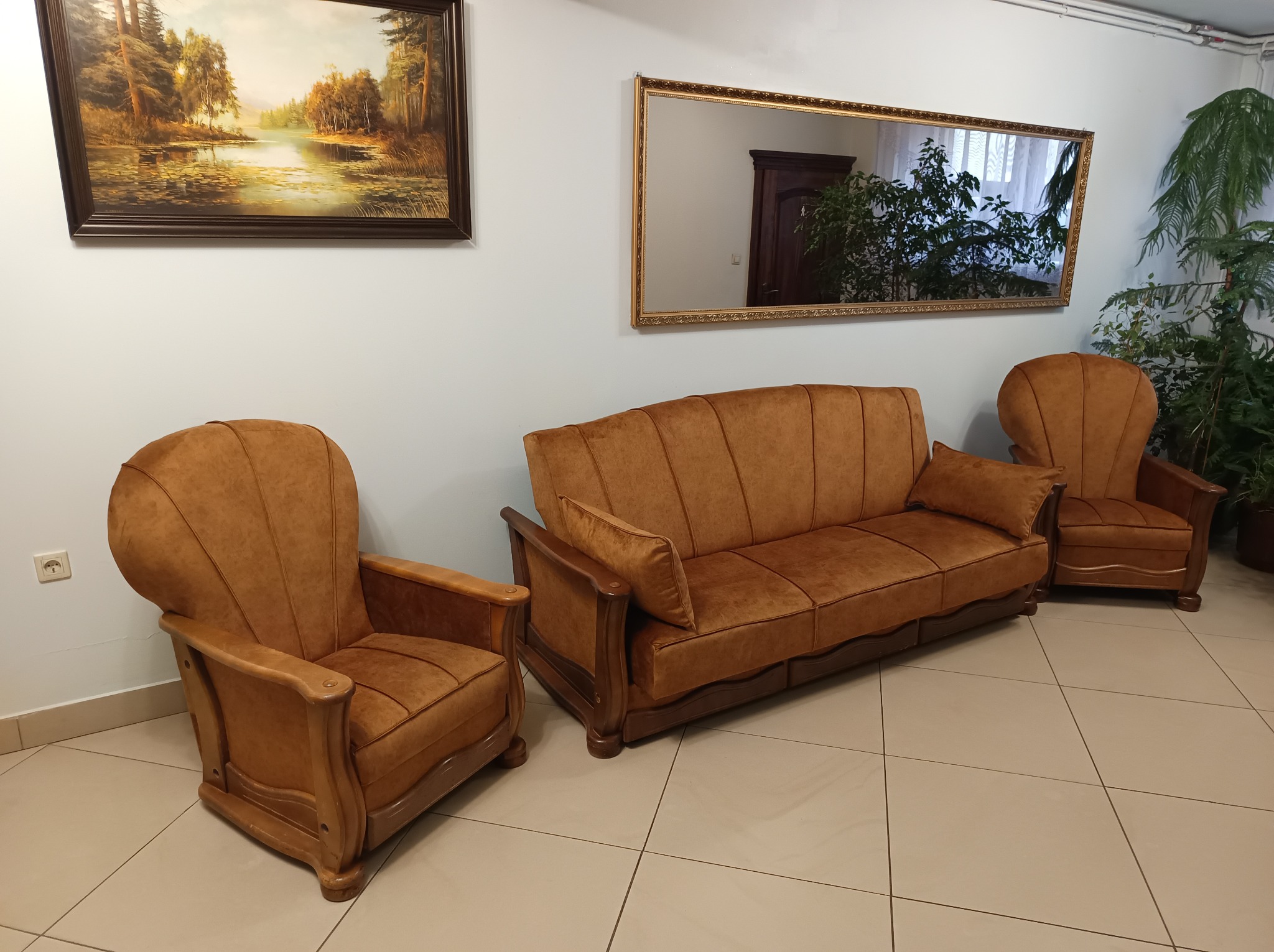 Komplet wypoczynkowy: sofa i dwa fotele w odcieniach brązu, z tapicerką z mikrofibry, w klasycznym wnętrzu z obrazem i lustrem w złotej ramie.