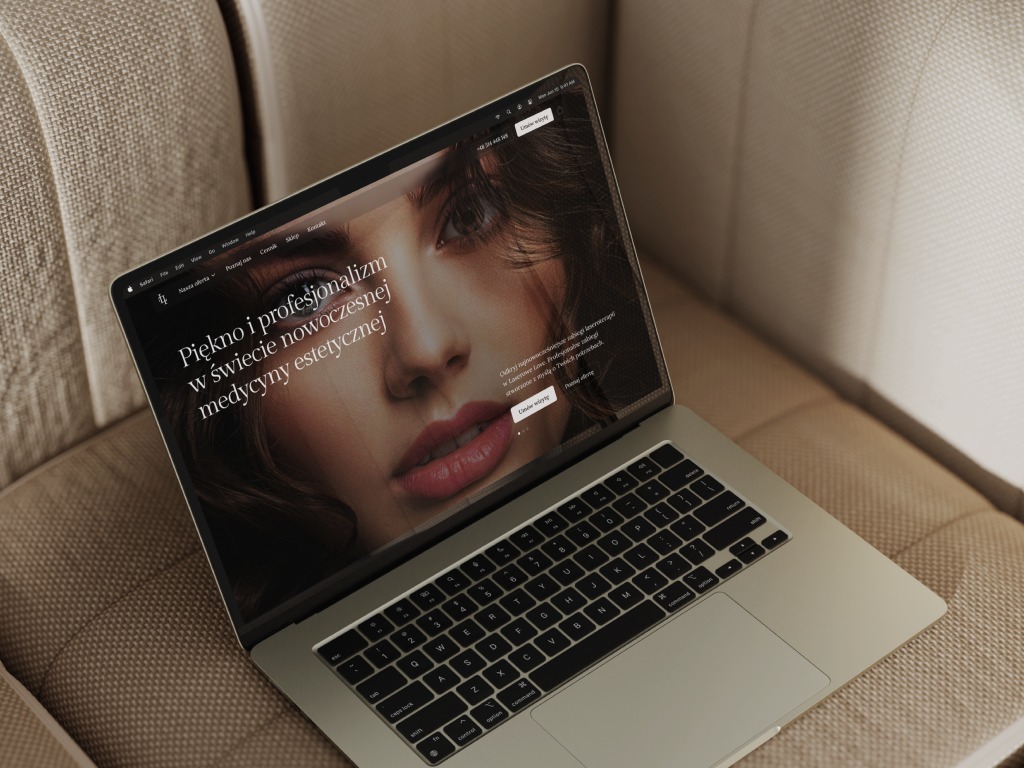 Laptop wyświetla projekt strony internetowej dla branży beauty z portretem kobiety. Minimalistyczny design, stonowana kolorystyka, nowoczesny układ elementów.