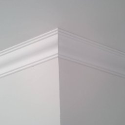Ernest - Detal wykończenia wnętrza: biała listwa dekoracyjna na styku ściany i sufitu, precyzyjnie zamontowana w rogu pomieszczenia.