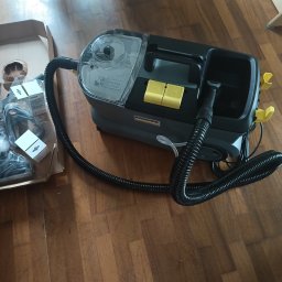 Barbara Wrobel-Tomecka - Profesjonalny odkurzacz piorący Karcher z akcesoriami w kartonie, gotowy do prania dywanów i tapicerek na drewnianej podłodze.