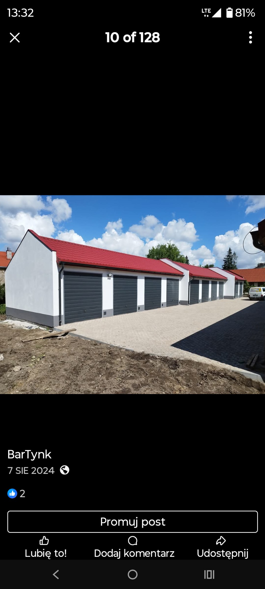 Rząd nowo wybudowanych garaży z czerwonymi dachami i szarymi bramami, świeżo otynkowane, z widocznym fragmentem terenu przed nimi.