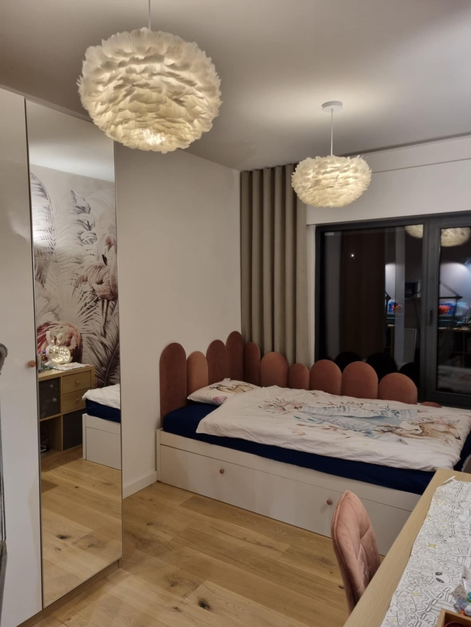 Pokój dziecięcy ze szafą z lustrem i łóżkiem z wezgłowiem w kształcie fal, Święciechowa. Lampy z piór dodają wnętrzu lekkości.