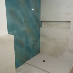 ProPerfect - Wykończona łazienka z kabiną typu walk-in, wyłożona płytkami w odcieniach beżu i turkusu. Widoczny odpływ liniowy i wnęka w ścianie. Minimalistyczny design.