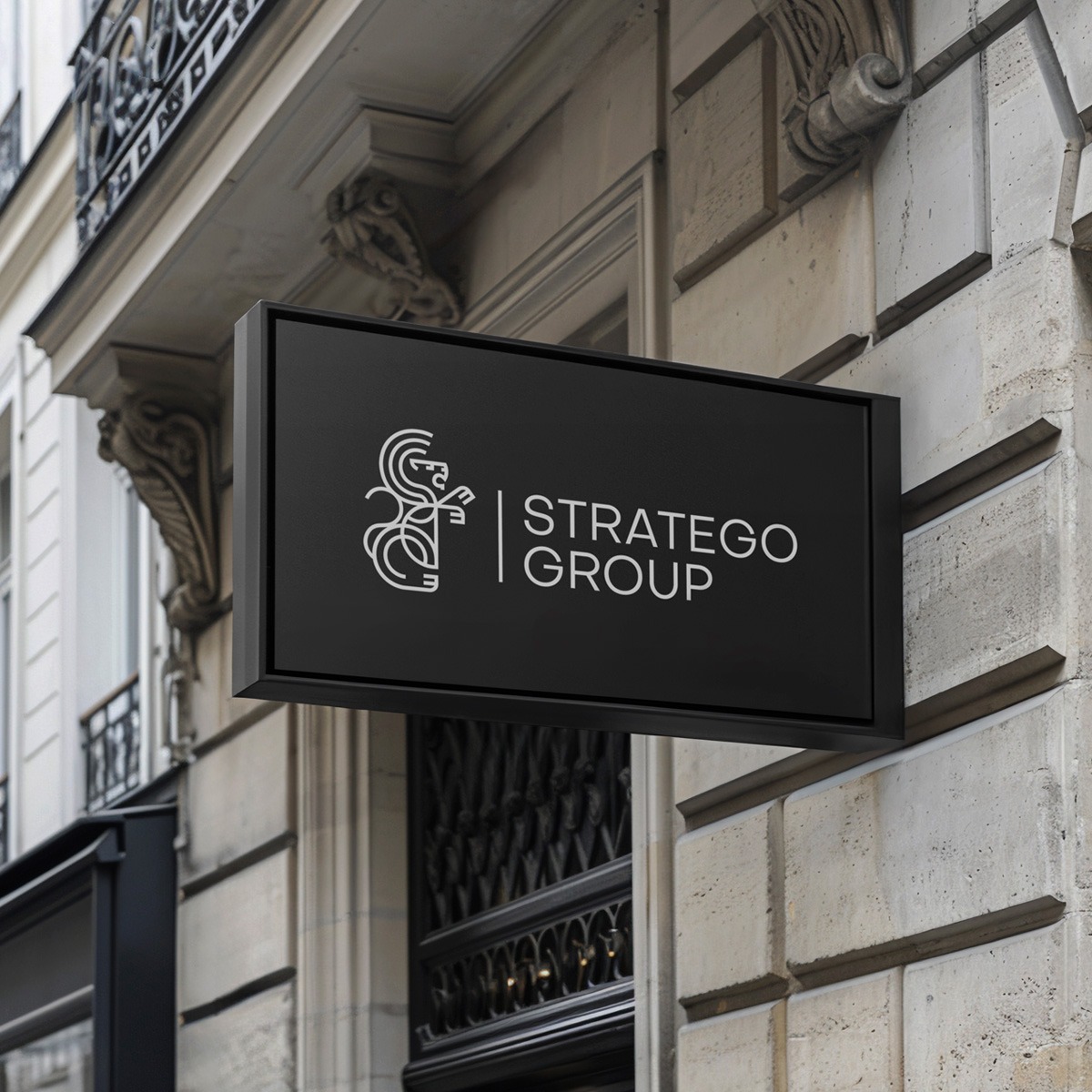 Elegancki, czarny szyld z logo i nazwą 'STRATEGO GROUP' na tle klasycznej fasady budynku. Minimalistyczny design, stonowana kolorystyka.