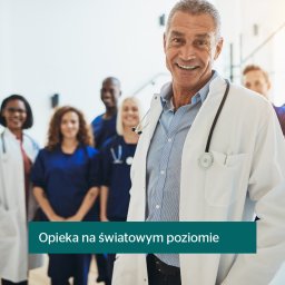 Pawel Marczak OVB Ubezpieczenia - Uśmiechnięty lekarz w białym fartuchu ze stetoskopem na tle zespołu medycznego, reprezentujący profesjonalizm i opiekę zdrowotną.