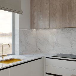 Michał Wilkosiński Conifer Media - Nowoczesna kuchnia w Jelcz-Laskowice: białe szafki, marmurowy backsplash, złota armatura przy oknie z widokiem na jezioro. Minimalistyczny design i naturalne światło.