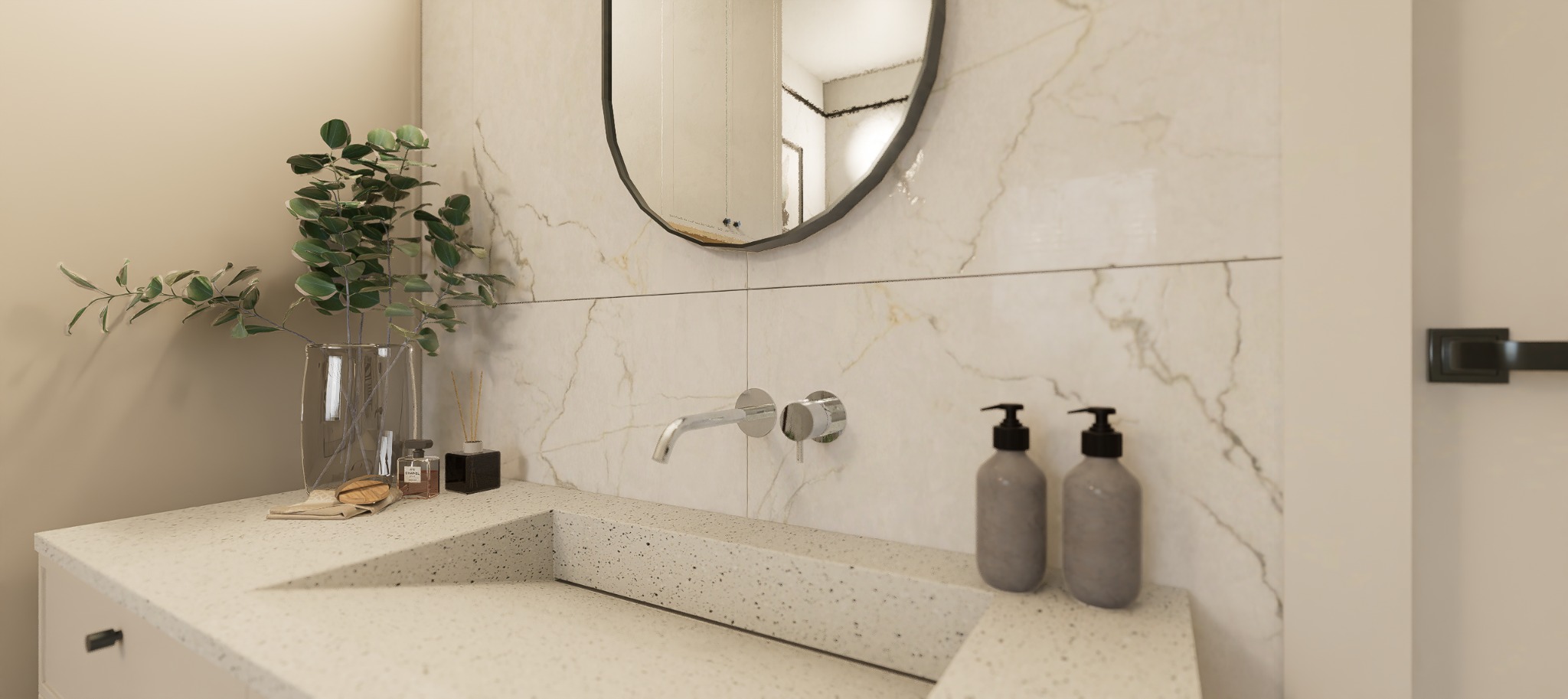 Elegancka łazienka: umywalka z blatem lastryko, owalne lustro z czarną ramą, marmurowe płytki i minimalistyczna armatura. Rośliny w wazonie dodają świeżości.
