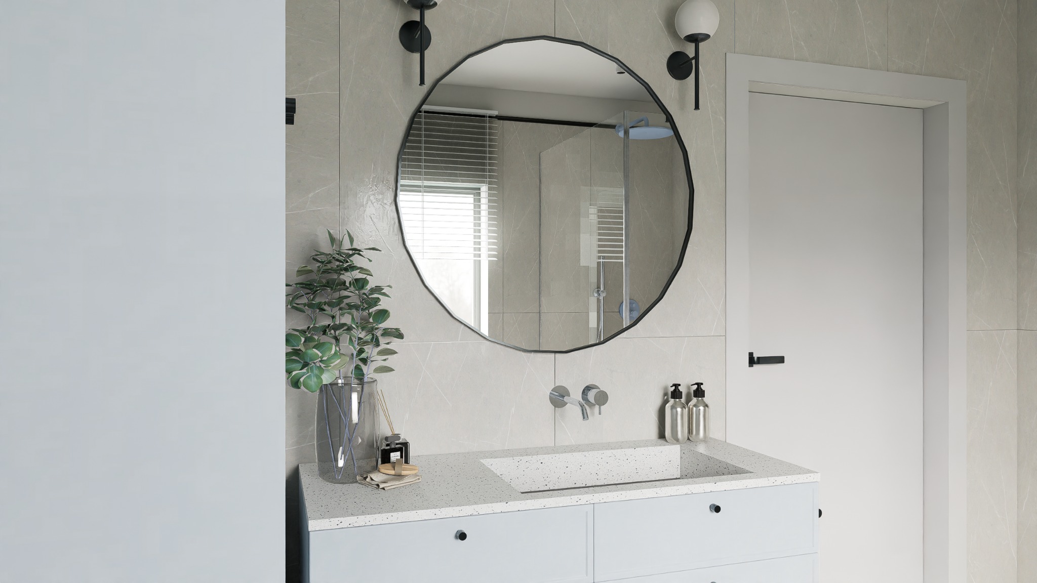 Stylowa łazienka z okrągłym lustrem o nieregularnym kształcie, minimalistyczną armaturą i rośliną w szklanym wazonie na blacie umywalki. Widoczna kabina prysznicowa.