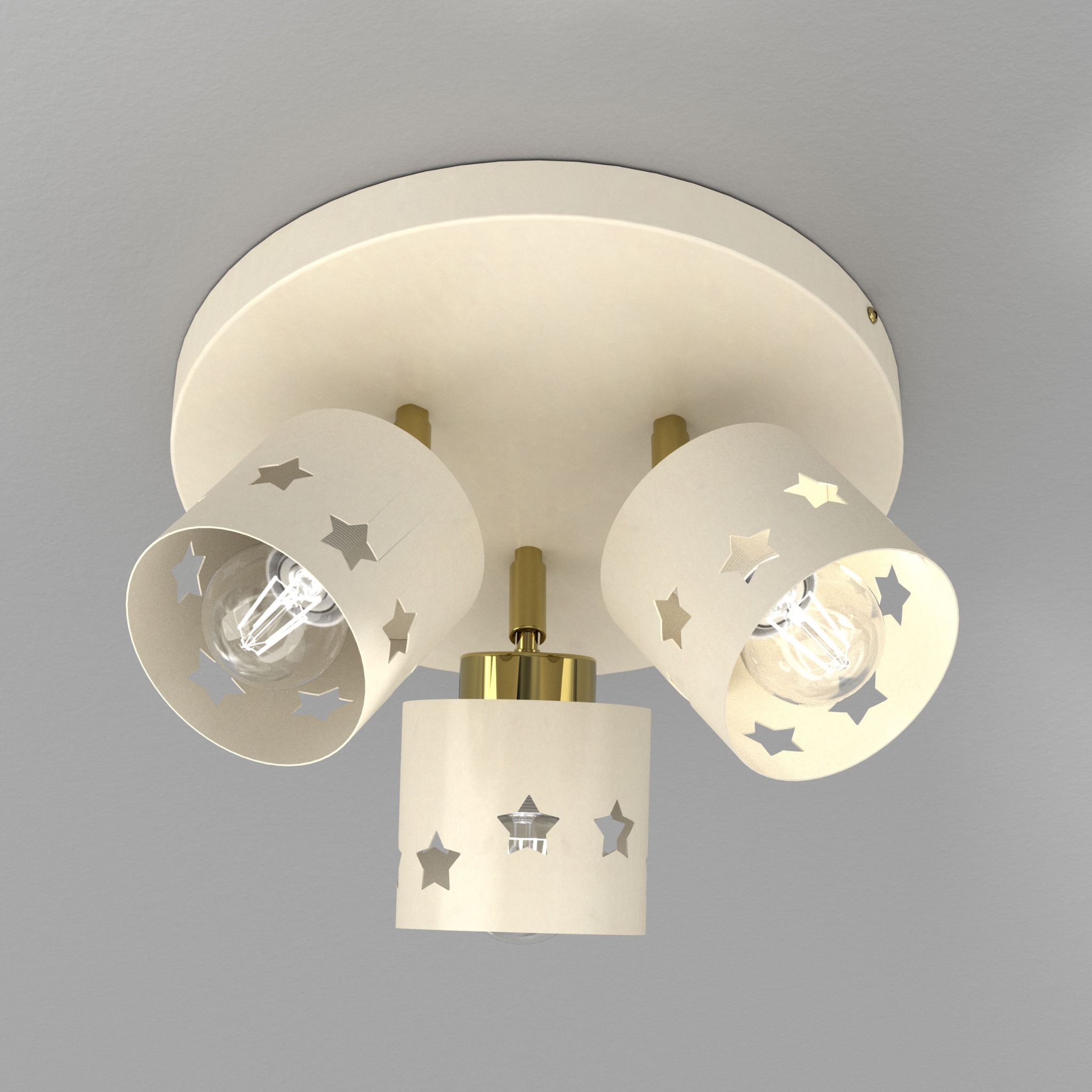Kremowa lampa sufitowa z trzema reflektorami w kształcie walców z wyciętymi gwiazdami, zamontowana na szarym suficie. Żarówki włączone.
