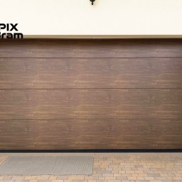 PixBram Dawid Kasprzyk - Brązowa brama garażowa segmentowa z poziomymi panelami o fakturze drewna, z logo firmy w lewym górnym rogu, na tle jasnej elewacji i kostki brukowej.