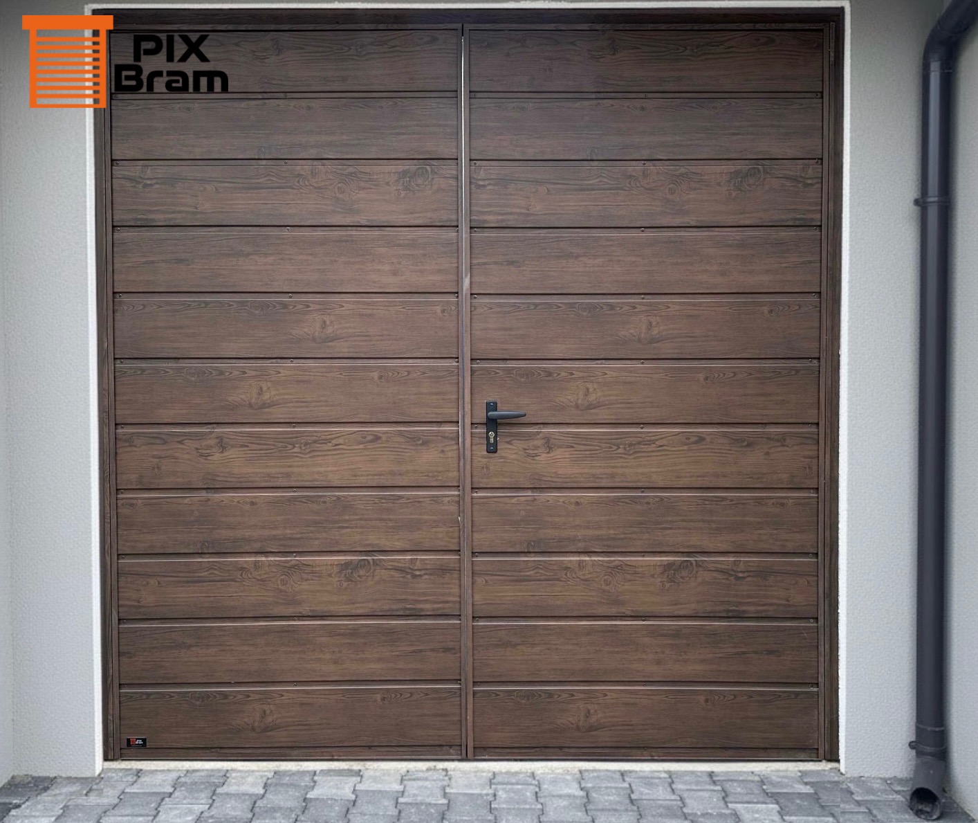 Dwuskrzydłowa brama garażowa z paneli imitujących drewno, z czarną klamką, na tle szarej ściany i kostki brukowej. Widoczny fragment rynny.