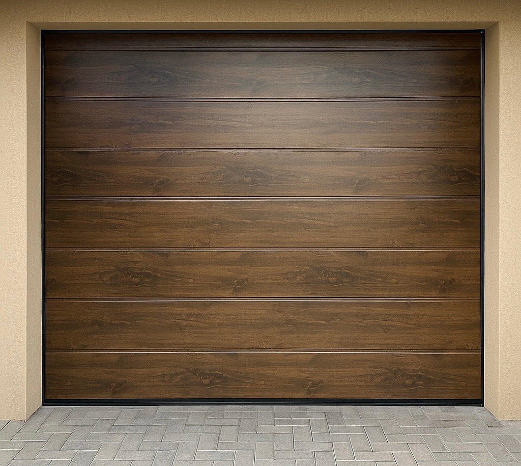 Segmentowa brama garażowa z paneli imitujących drewno, w kolorze orzechowym, z delikatnymi poziomymi przetłoczeniami, na tle beżowej elewacji i szarej kostki brukowej.