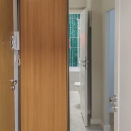 szafa wnękowa w przepokoju, kolor szafy dostosowany do drzwi wejściowych, lustro optycznie powiększa niewielki przedpokój